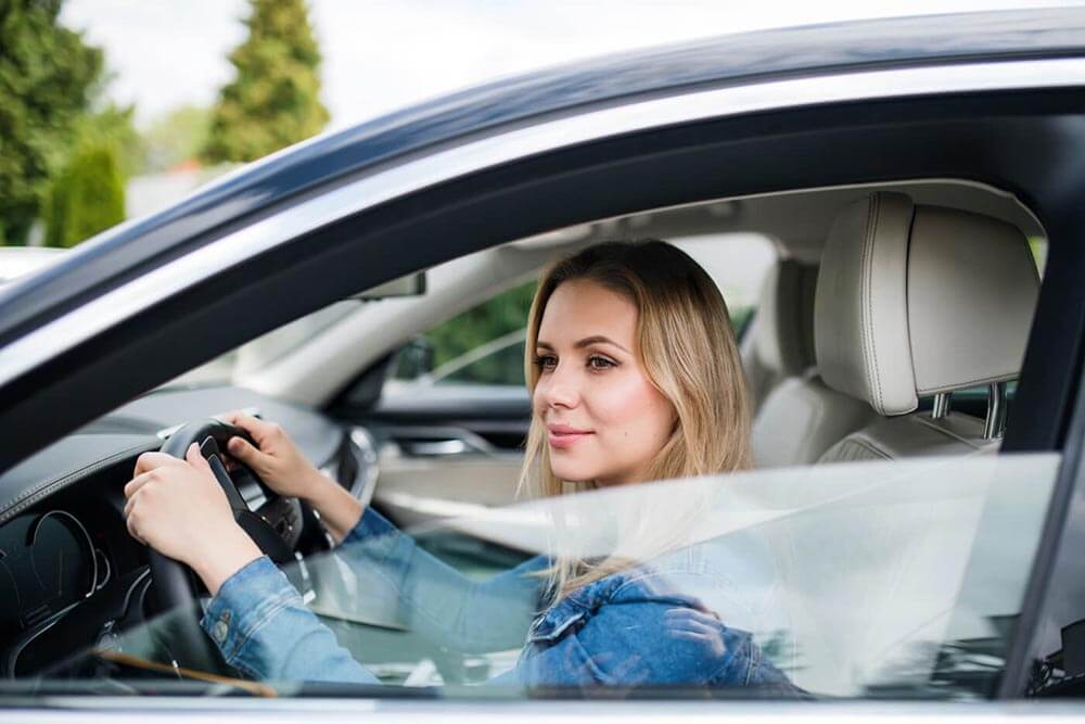 Femme assise du côté conducteur d'une voiture