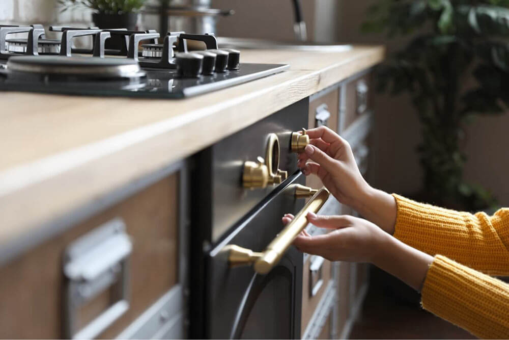 Person's hands using buttons on the stove