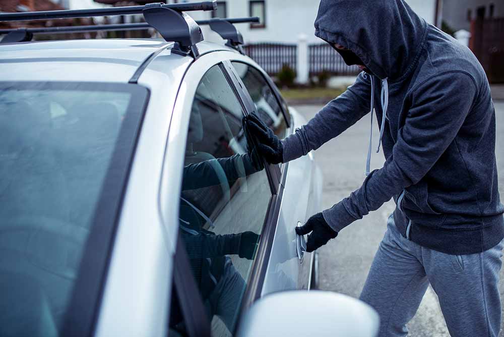 Voleur tentant de s'introduire dans une voiture