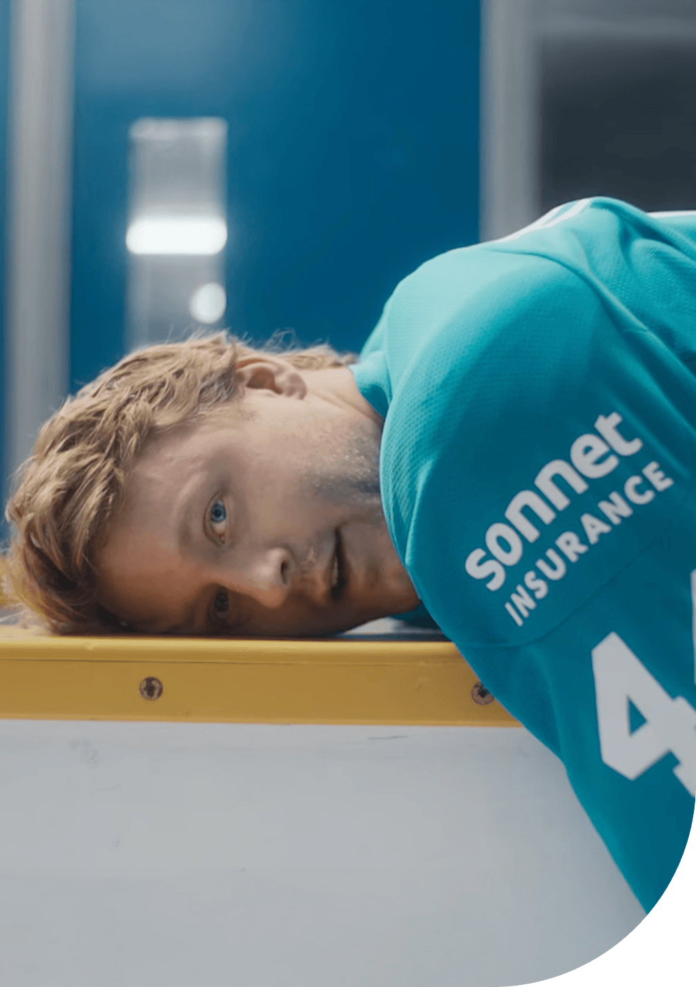 Morgan Rielly of the Toronto Maple Leafs wearing a teal Sonnet Insurance jersey with number 44, lying on the boards inside a hockey arena